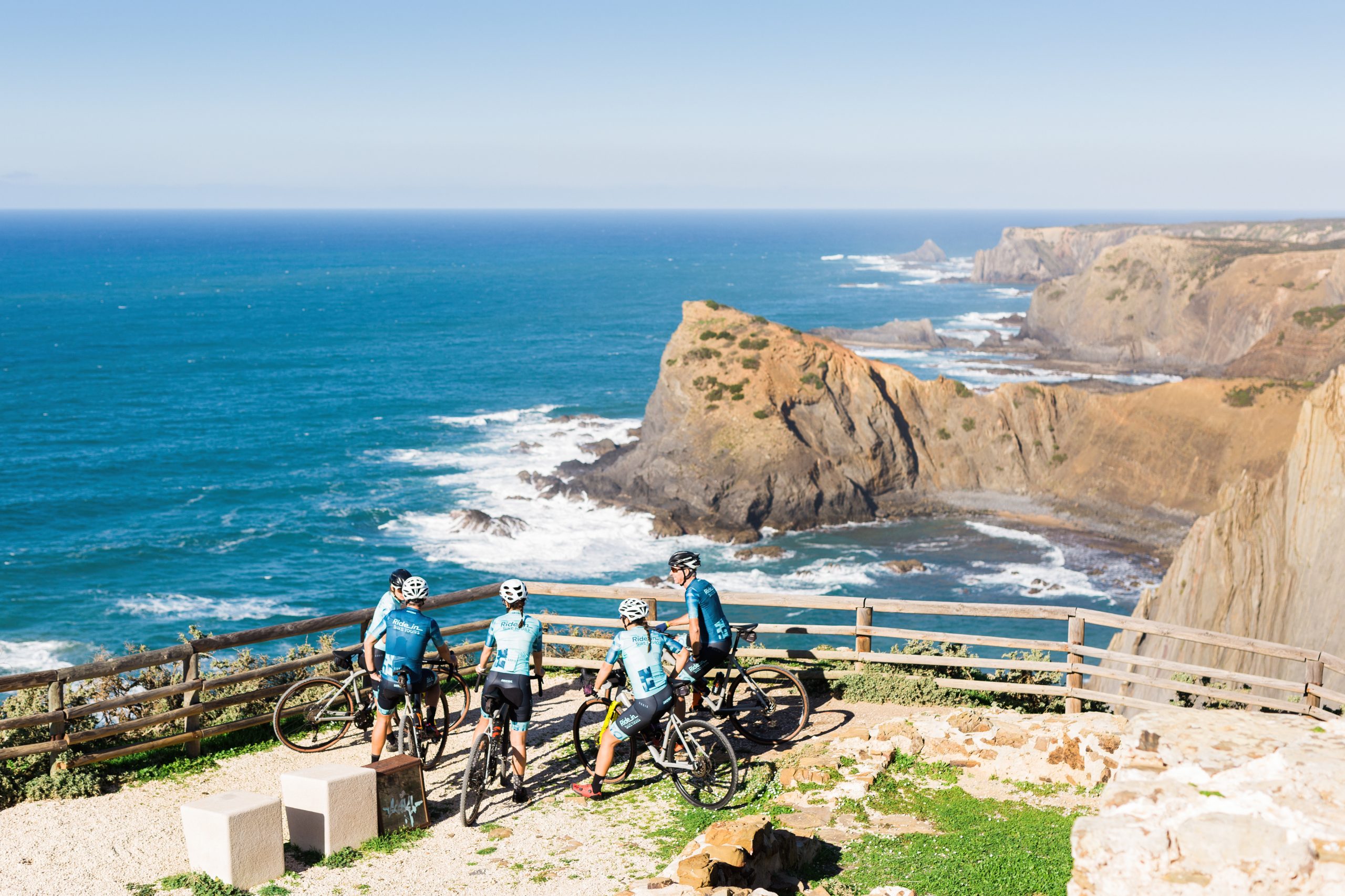 Cyclists riding parallel to Atlantic waves