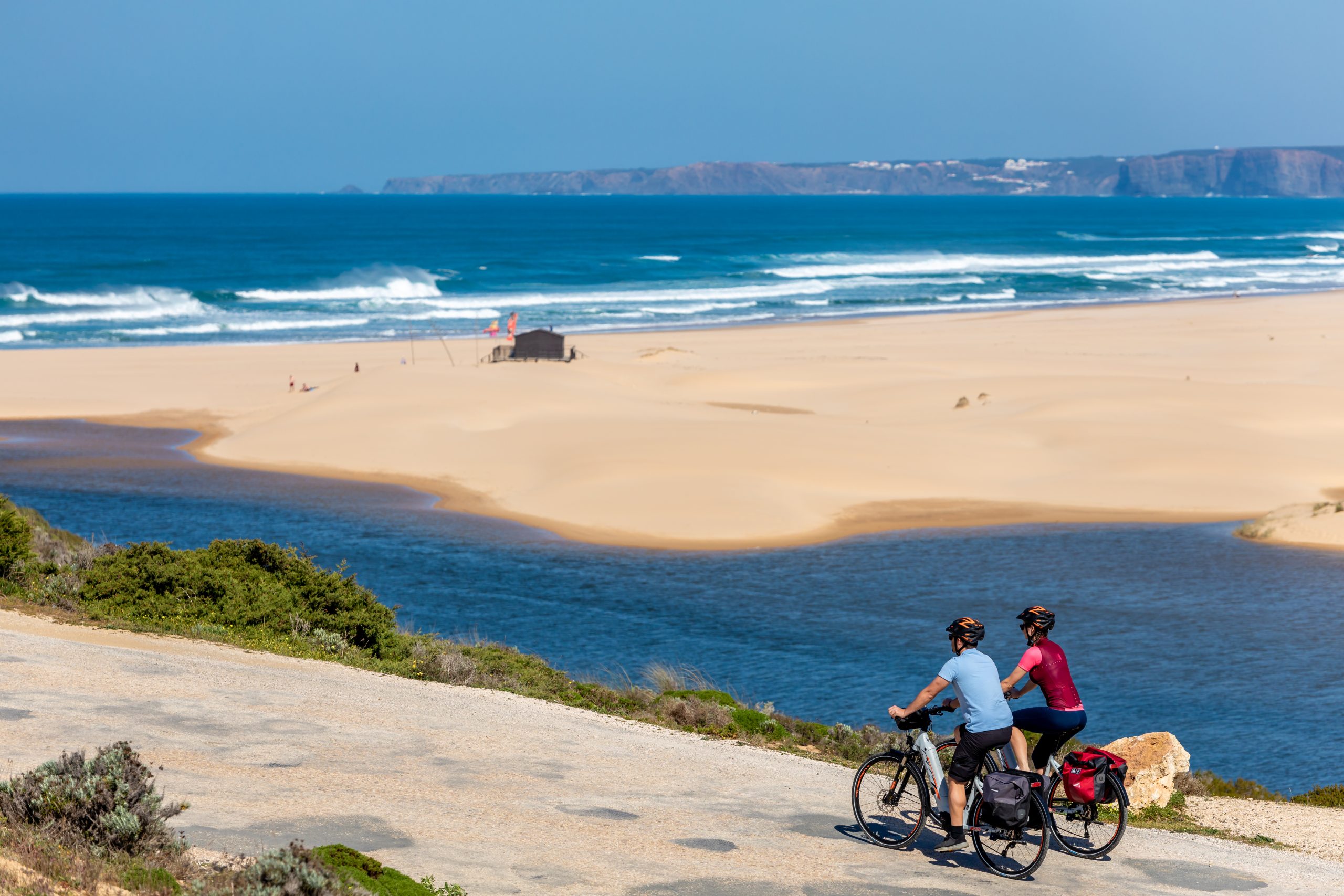 Cyclists pedaling near Atlantic beach in Portugal