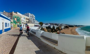 Cyclists riding along the coast of Albufeira in the Algarve during EuroVelo 1 bike tour