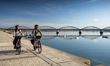 Cyclists riding along the EuroVelo 1 route by the river in Vila Real de Santo António Algarve